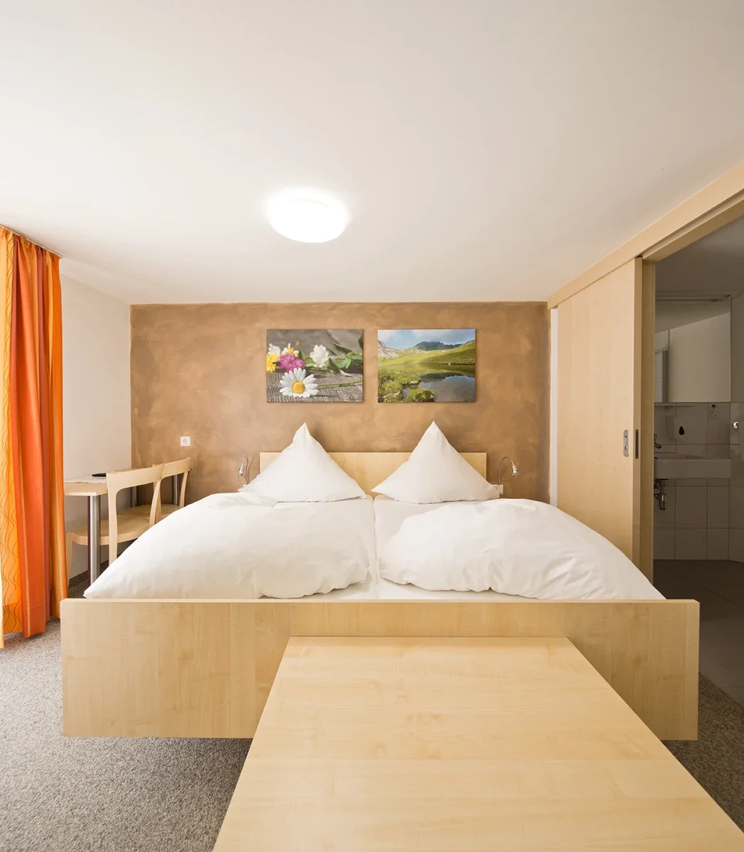 Helles Gästezimmer mit Holzmöbeln in der Pension zum Löwen in Dornbirn