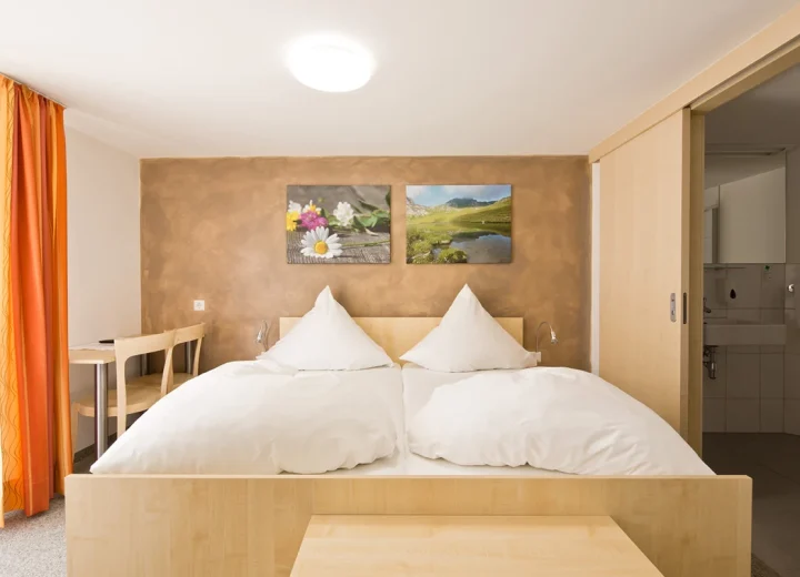 Helles Gästezimmer mit Holzmöbeln in der Pension zum Löwen in Dornbirn